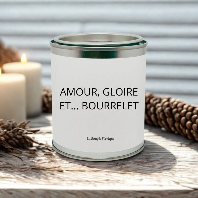 Bougie Personnalisée "Amour Gloire et Bourrelet", posée sur une table en bois blanc avec d'autres bougies à côté.