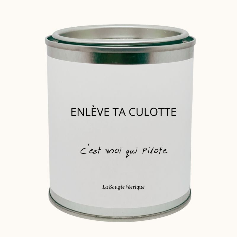 Bougie Personnalisée "Enlève ta Culotte C'est Moi qui Pilote", on peut lire le message humoristique, le contenant de la bougie est fermé. Fond beige clair.