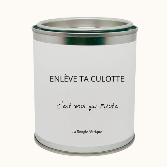 Bougie Personnalisée "Enlève ta Culotte C'est Moi qui Pilote", on peut lire le message humoristique, le contenant de la bougie est fermé. Fond beige clair.
