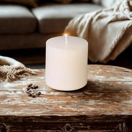 Bougie Pilier Blanche et Intemporelle, posée sur une table en bois dans une ambiance zen.