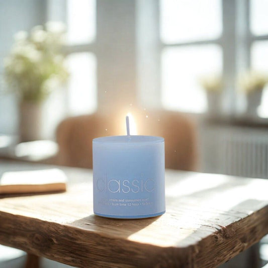 Bougie Pilier Bleu Tentation, disposée sur une table en bois dans une ambiance cocooning.