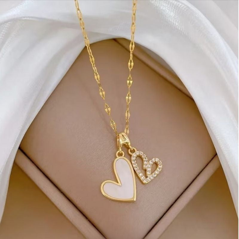 Bougie Saint Valentin Coffret Tendre Moment, gros plan sur le collier blanc et or en forme de coeur avec des strass.