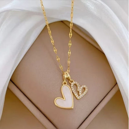 Bougie Saint Valentin Coffret Tendre Moment, gros plan sur le collier blanc et or en forme de coeur avec des strass.