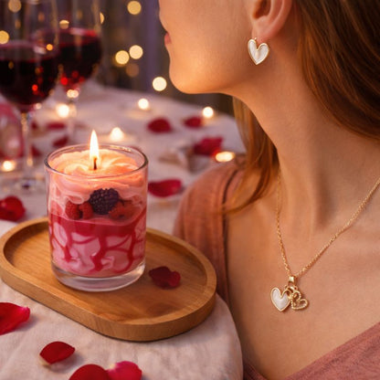 Bougie Saint Valentin Coffret Tendre Moment, une personne porte la parure de bijoux et devant elle il y a la bougie aux fruits rouges qui est allumée. Ambiance romantique.
