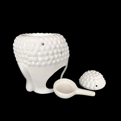 Brule Parfum Bouddha Blanc Élégant avec tête amovible et cuillère pour fondant parfumé et sur fond noir.