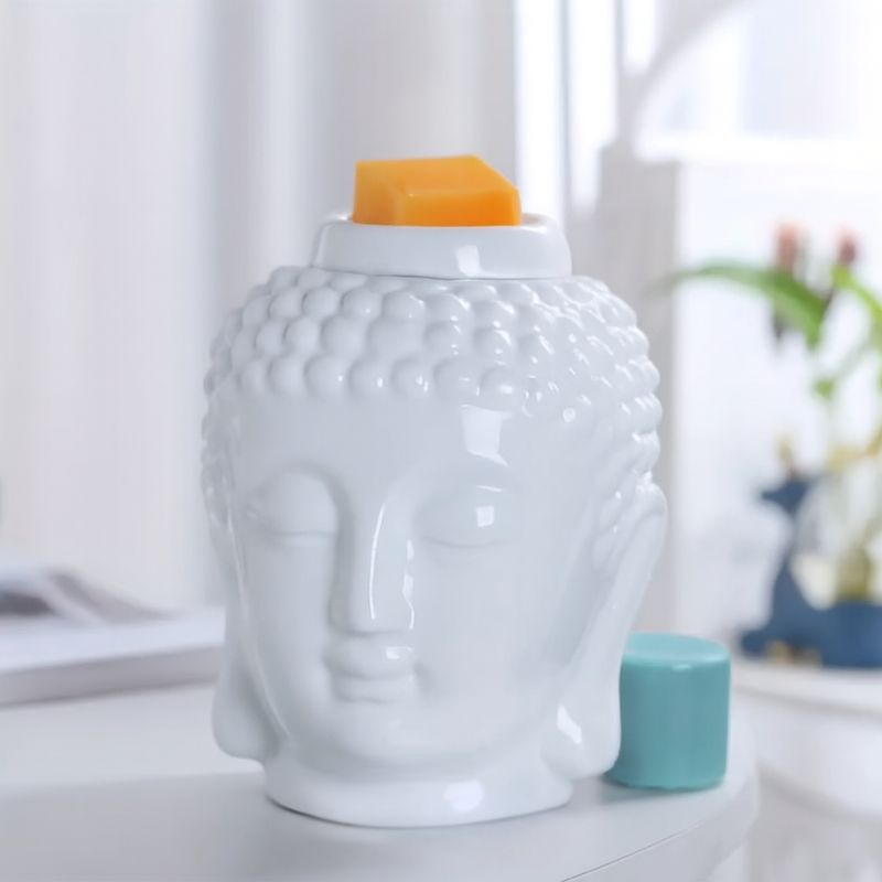 Brule Parfum Bouddha Blanc Raffiné, avec du fondant parfumé en décoration et posé sur une table blanche.