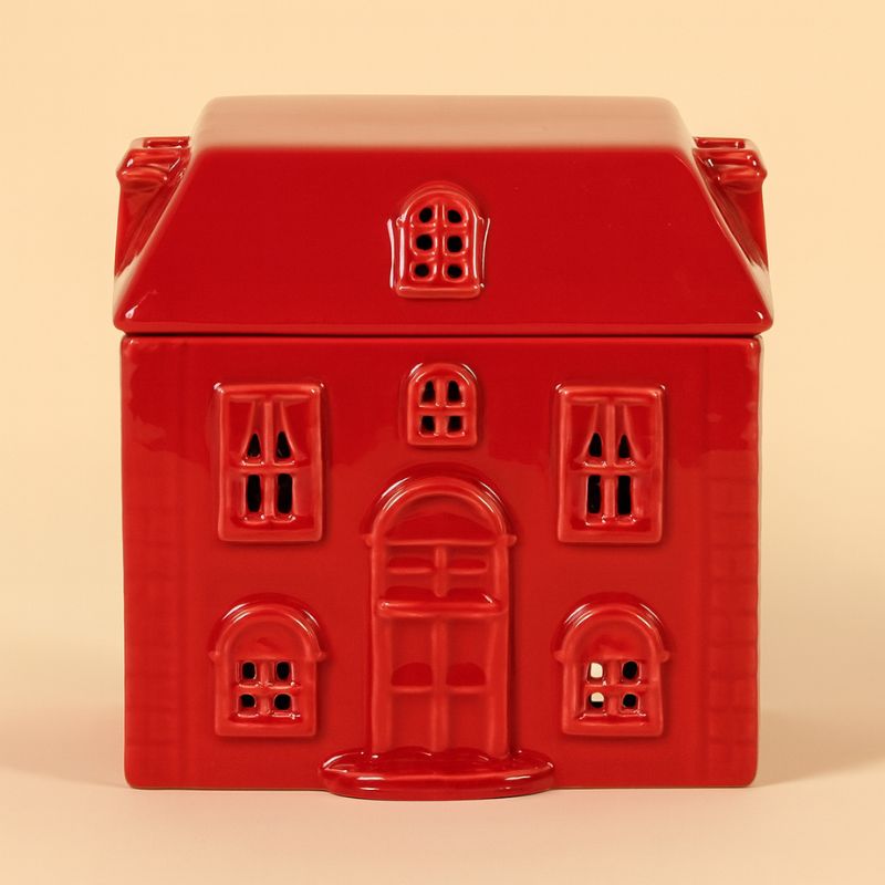 Brule Parfum Chalet Enchanté, de couleur rouge et en forme de maison de maître et sur fond beige clair.