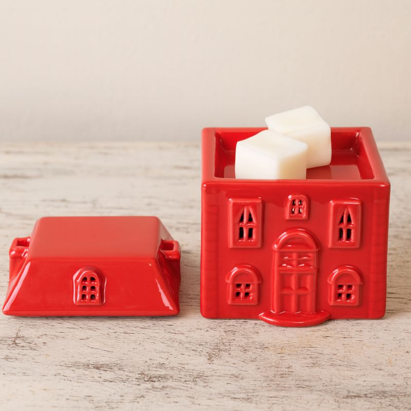 Brule Parfum Chalet Enchanté, le toit est amovible pour glisser des fondants parfumés et les faire fondre, posé sur une table en marbre.