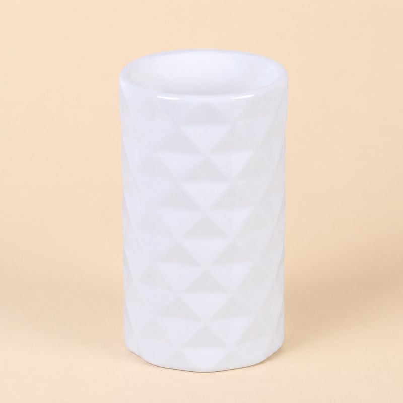 Brule Parfum Design Organique en céramique blanche au design géométrique moderne, intérieur chaleureux. Sur fond beige clair.