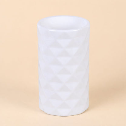 Brule Parfum Design Organique en céramique blanche au design géométrique moderne, intérieur chaleureux. Sur fond beige clair.