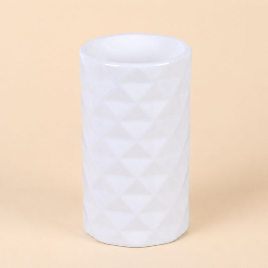 Brule Parfum Design Organique en céramique blanche au design géométrique moderne, intérieur chaleureux. Sur fond beige clair.