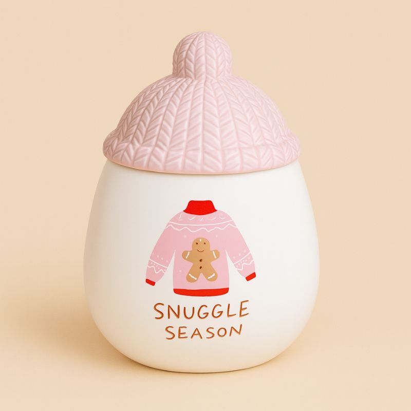 Brule Parfum Douceur Tricotée Rose, de couleur blanc et rose avec le couvercle en effet tricoter et sur fond beige clair.