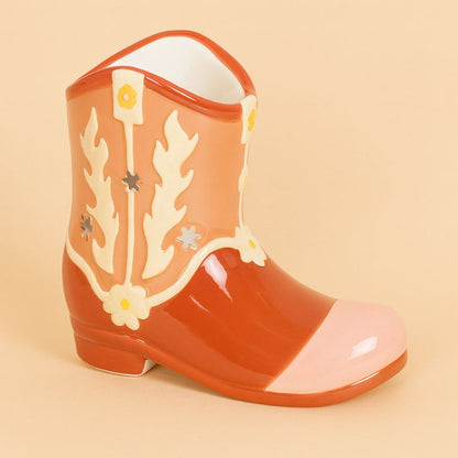Brule Parfum Far West Botte Western en céramique, forme de botte cowboy orange et beige avec motifs floraux découpés, présenté sur fond beige clair.