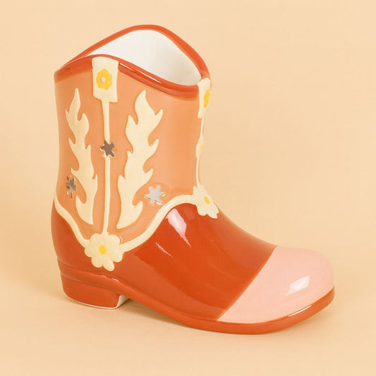 Brule Parfum Far West Botte Western en céramique, forme de botte cowboy orange et beige avec motifs floraux découpés, présenté sur fond beige clair.