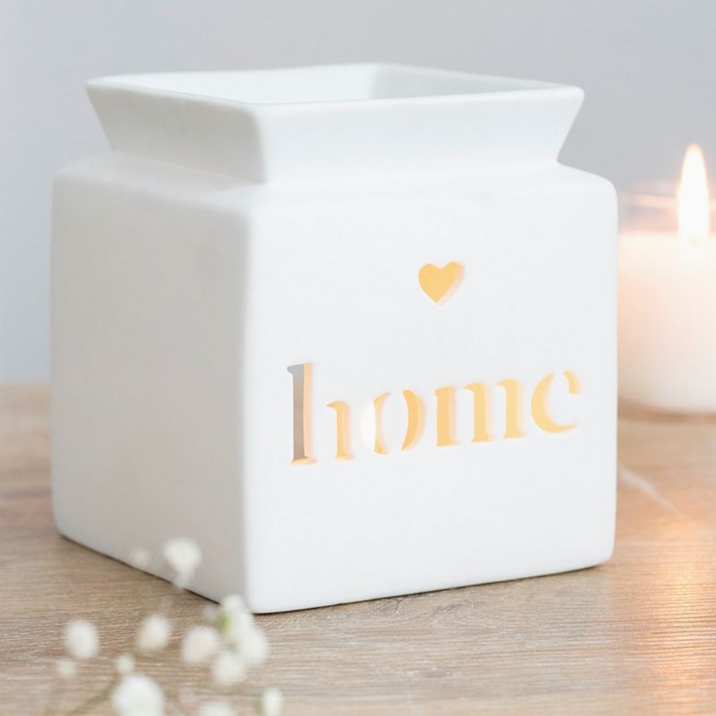Brule Parfum Home Minimaliste, de couleur blanc ajouré « home » illuminé par une bougie, lumière chaleureuse et style épuré pour fondants parfumés.