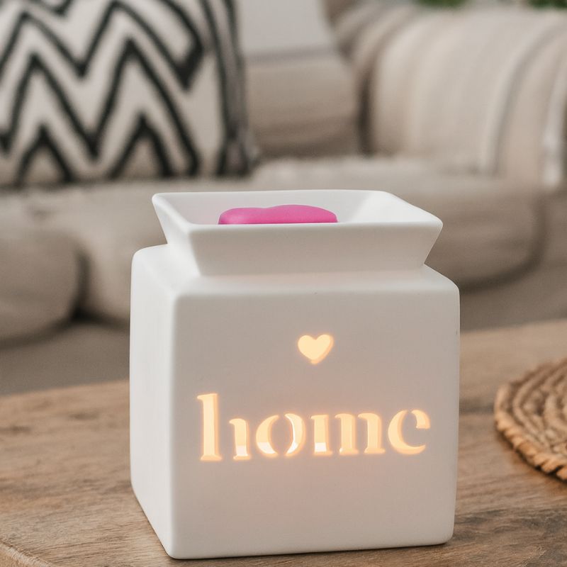 Brule Parfum Home Minimaliste, Modèle blanc ajouré « home » allumé, avec fondant parfumé en forme de cœur, diffusant une lumière douce dans un intérieur cosy.