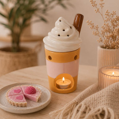 Brule Parfum Latte Gourmand avec bougie chauffe-plat allumée et fondant parfumé tartelette fraise découpé, dans une ambiance scandinave chaleureuse.