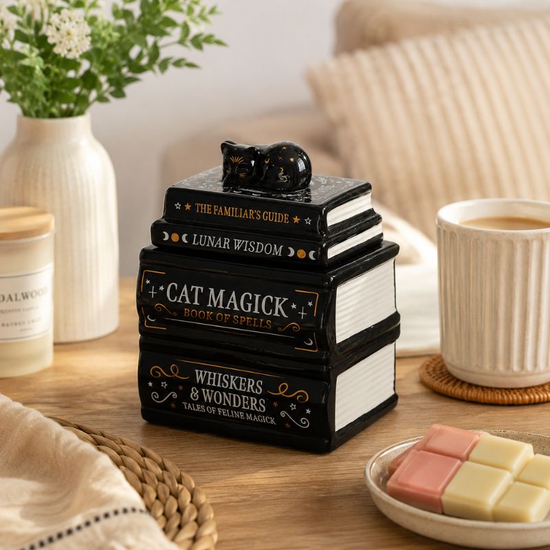 Brule Parfum Livre Magique Chat Noir sur une table de salon avec fondants parfumés dans une ambiance cocooning.