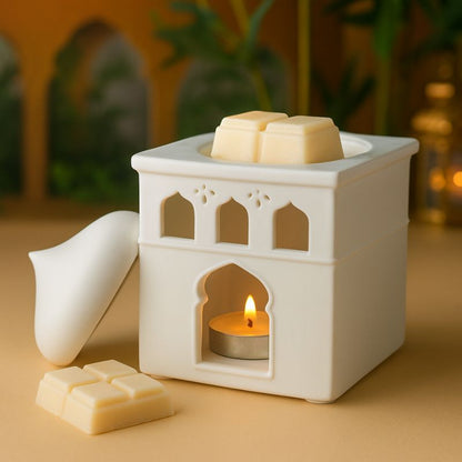 Brule Parfum Lueur d’Orient, avec du fondant à l’intérieur du brûleur, il est allumé et posé sur une table en bois. Ambiance orientale.