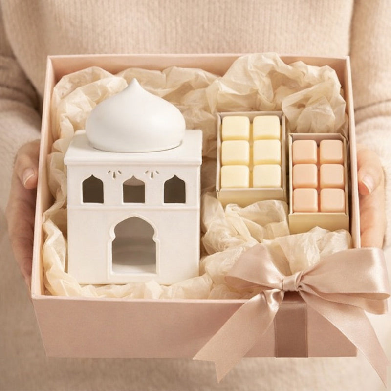 Brule Parfum Lueur d’Orient en coffret cadeau avec fondants parfumés, tenu dans les mains, présenté dans une ambiance douce et élégante.