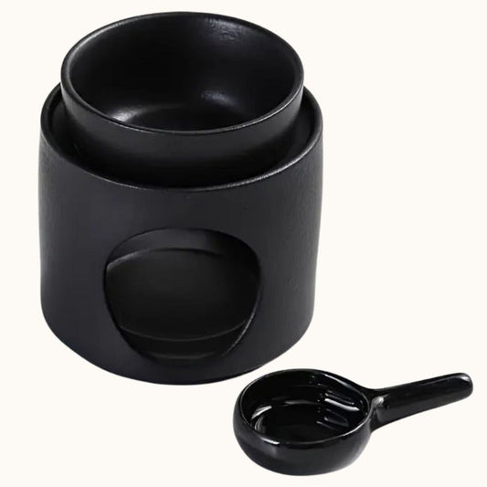 Brule Parfum Noir Design avec coupelle amovible et support pour bougie chauffe-plat pour diffuser un fondant parfumé dans la maison et sur fond beige clair.