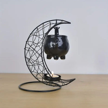 Brule Parfum Noir Rituel Mystique, de couleur noire et disposé sur une table en bois. Fond gris clair.