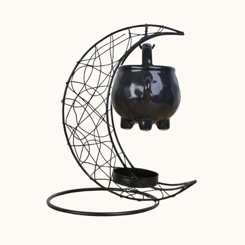 Brule Parfum Noir Rituel Mystique, de couleur noire, en forme de lune et avec son petit chaudron. Sur fond beige clair.