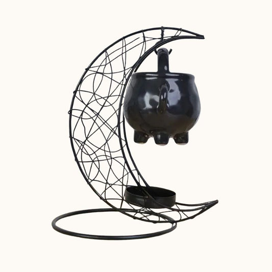 Brule Parfum Noir Rituel Mystique, de couleur noire, en forme de lune et avec son petit chaudron. Sur fond beige clair.