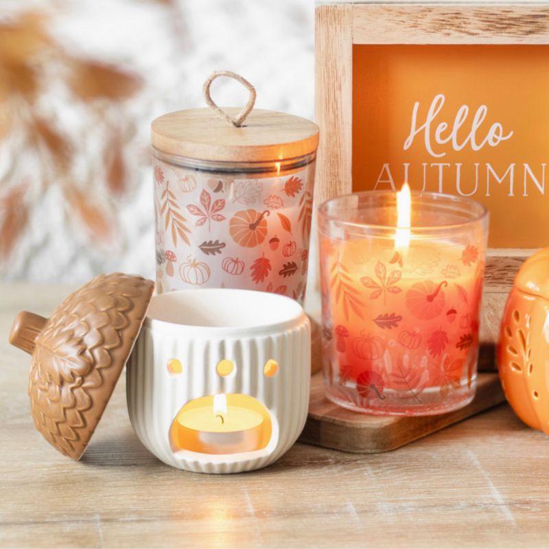 Brule Parfum Noisette d'Automne, le bruleur est ouvert et vu de dos avec une bougie chauffe plat à l’intérieur, ambiance automnale.