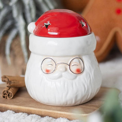 Brule Parfum Pére Noël Magique rouge et blanc, mise en scène festive avec décor Noël.