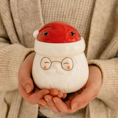 Brule Parfum Pére Noël Magique tenu dans les mains, idée cadeau Noël chaleureuse.