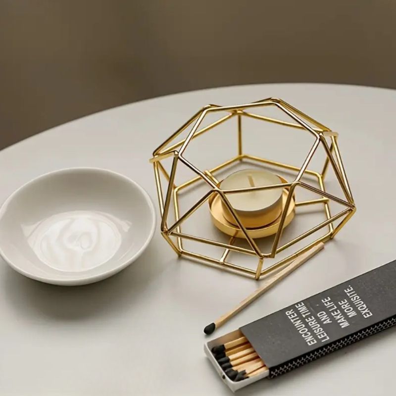 Brule Parfum Style Contemporain, il est posé sur une table blanche avec des allumette à côté.