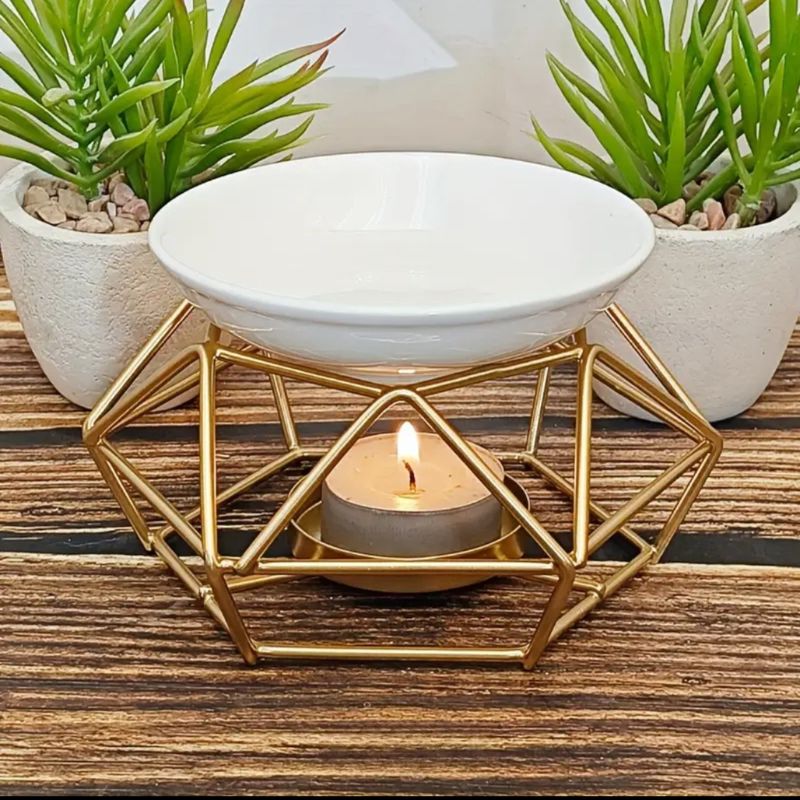 Brule Parfum Style Contemporain, dans une ambiance zen, il est posé sur une table en bois avec deux pots de fleurs derrière.