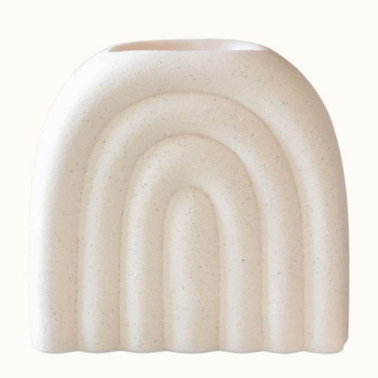 Brule Parfum XL Arc Déco Chic, de couleur blanc cassé et moucheté, avec une forme arquée et sur fond beige clair.