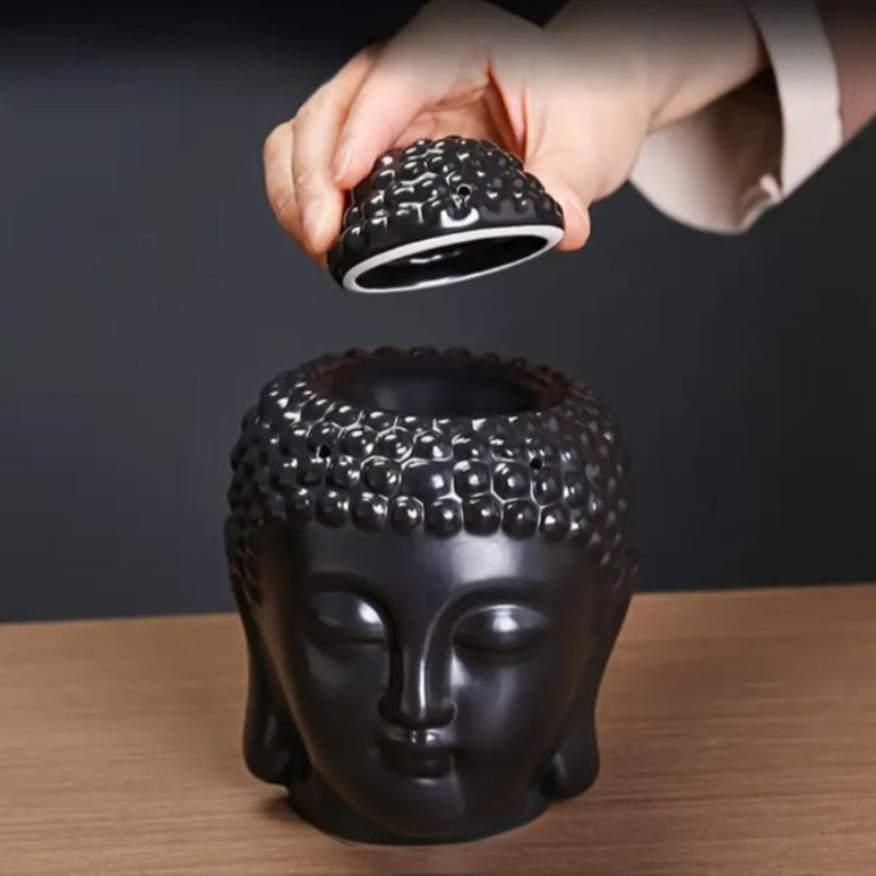 Brule Parfum Bouddha Noir Élégant, de couleur noire et disposé sur une table en bois, avec une personne qui enlève le chapeau.
