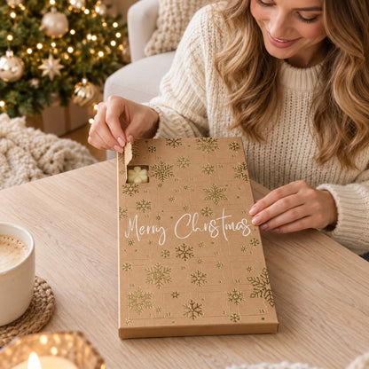 Calendrier de l’Avent Fondant Parfumé Noël Féerique dont une femme ouvre une case pour découvrir un fondant. Ambiance festive.