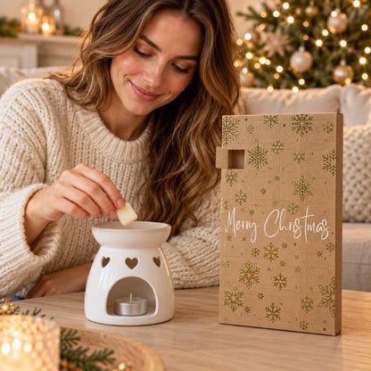 Calendrier de l’Avent Fondant Parfumé Noël Féerique ouvert près d’une femme déposant un fondant dans un brûle-parfum blanc. Ambiance féerique.