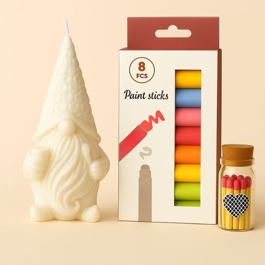 Coffret Bougie à Décorer Gnome Mystique, avec sa bougie blanche, ses feutres et ses allumettes. Sur fond beige clair.