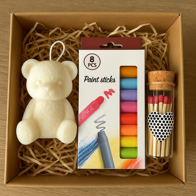 Coffret Bougie à Décorer Mission Câlin, la bougie blanche, les feutres et les allumettes présentés dans un coffret cadeau.