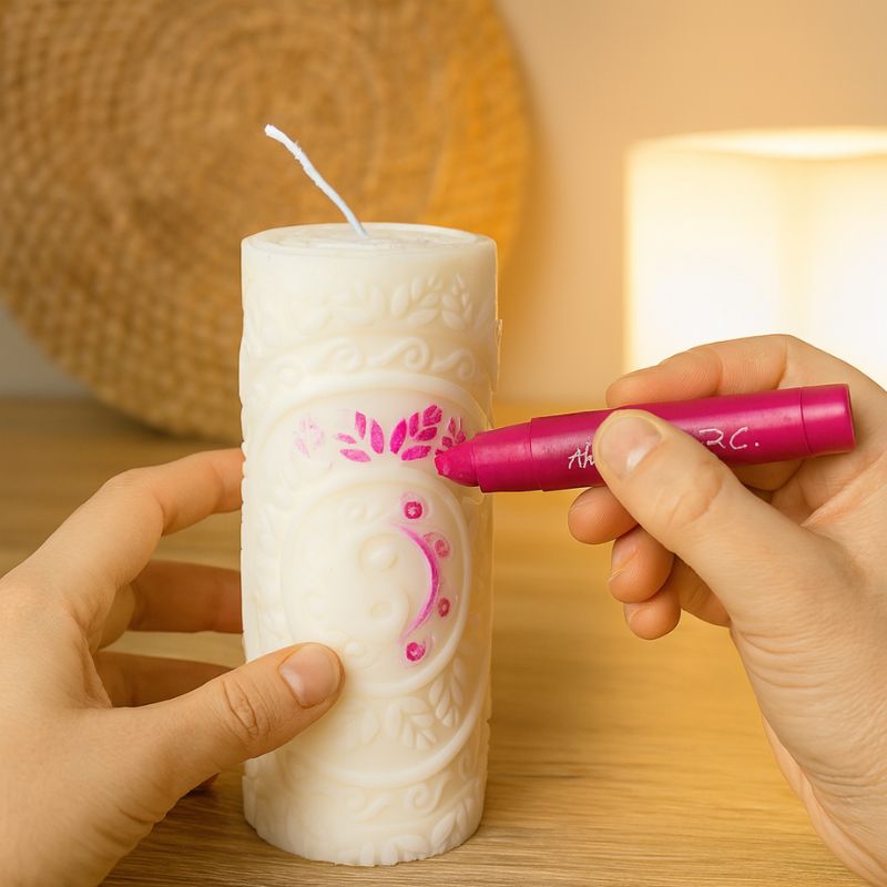 Coffret Bougie à Décorer Pilier Sculpté, une personne est en train de colorier en rose la bougie blanche. Ambiance créative.