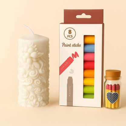Coffret Bougie à Décorer Poésie de Cire, avec une bougie blanche, des feutres cire et des allumettes. Sur un fond beige clair.