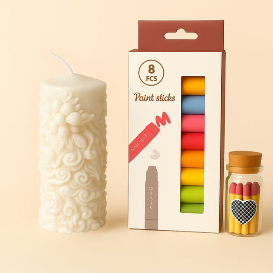 Coffret Bougie à Décorer Poésie de Cire, avec une bougie blanche, des feutres cire et des allumettes. Sur un fond beige clair.