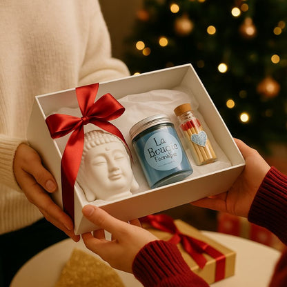 Coffret Bougie Douceur Scandinave, deux personnes s'offrent le coffret-cadeau, avec le brûleur, le plateau en bois, le fondant parfumé et les allumettes. Dans une ambiance festive.