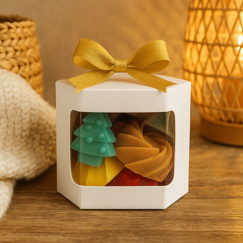 Coffret Bougie Fondant Parfumé Ambiance de Noël, posé sur une table en bois et dans une ambiance cocooning.