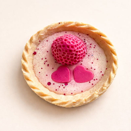 Fondant Parfumé Tartelette Fraise Gourmande en forme de dessert, avec cœurs roses et fraise décorative, sur fond beige clair minimaliste.