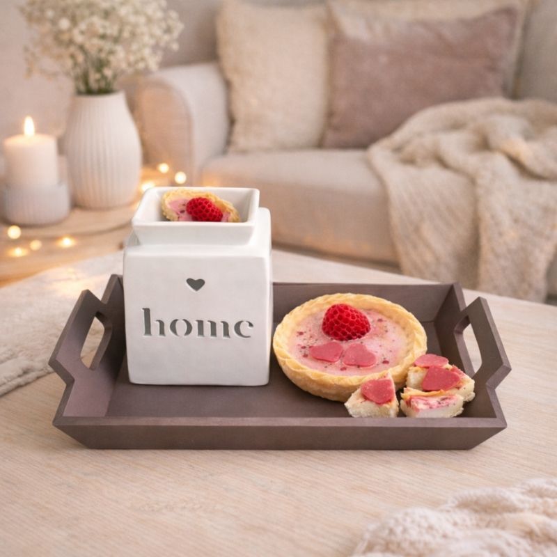 Fondant Parfumé Tartelette Fraise Gourmande avec brûle-parfum blanc Home sur plateau en bois, ambiance cocooning dans un salon lumineux.