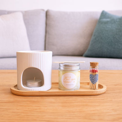 Coffret Bougie Rituel Féérique, il est disposé sur une table basse dans un salon. Ambiance cocooning.