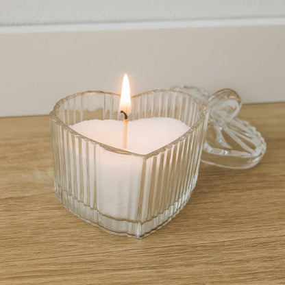 Coffret Bougies Perles Rituel Cocooning, dans le contenant en verre y est déposé la cire perle blanche, avec la mèche qui est allumée. Posé sur une table en bois.