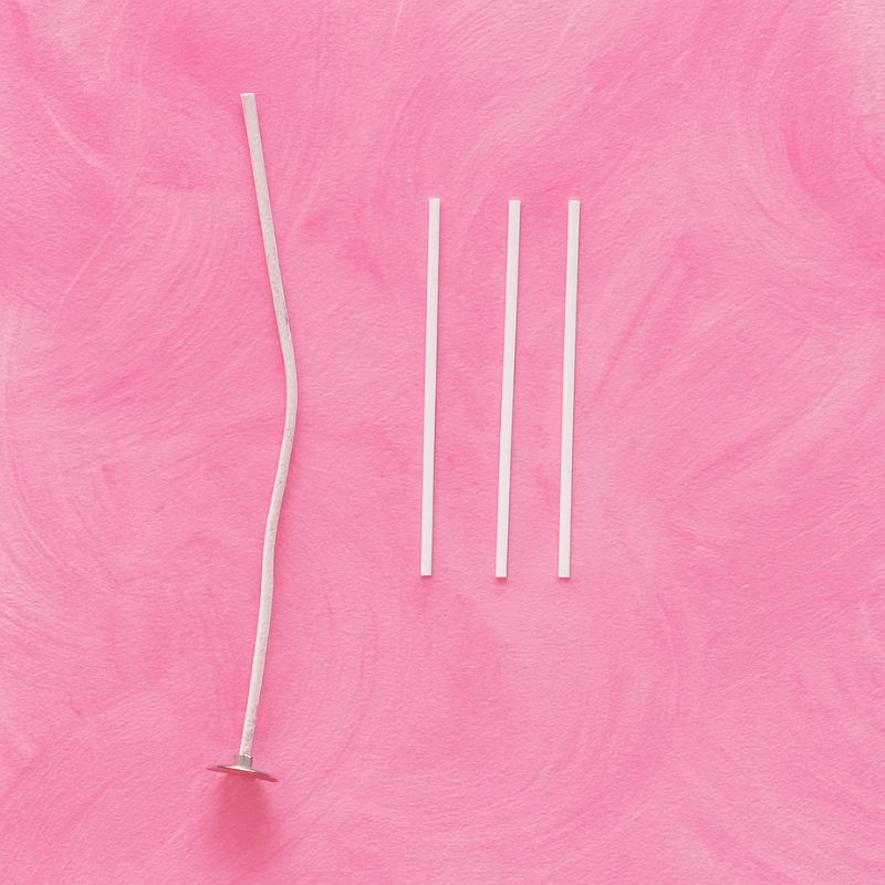Coffret Bougies Perles Rituel Cocooning, présentation des différentes taille de mèche comprise dans ce coffret et sur fond rose.