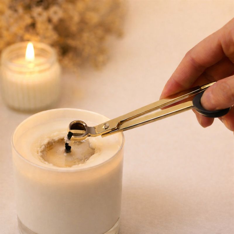 Éteignoir pour Bougie et Coupe Mèche, une personne a pris le ciseau à bougie pour couper la mèche en coton. Ambiance cocooning.